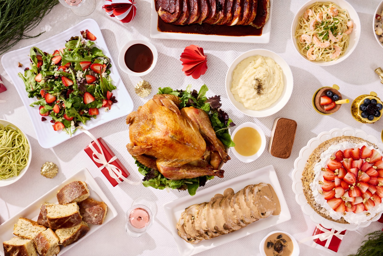 Mesa navideña completa con pavo, lomo, ensalada, puré, pasta y pastel de fresas